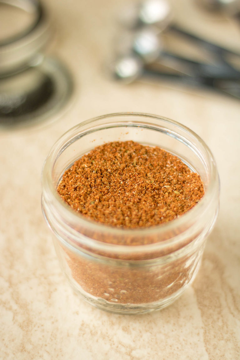 A jar with an orange seasoning mix.