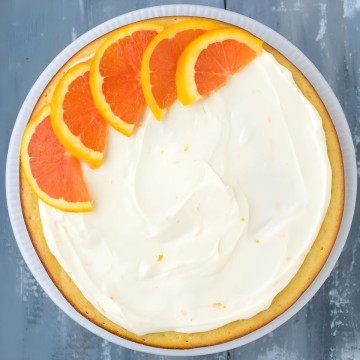 A cake with icing and orange slices on top.