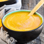 A bowl with orange soup in it.