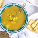 Potato soup in a blue and white bowl.