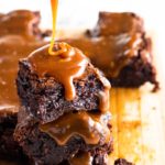 stack of three fudgy brownies with salted caramel sauce on top