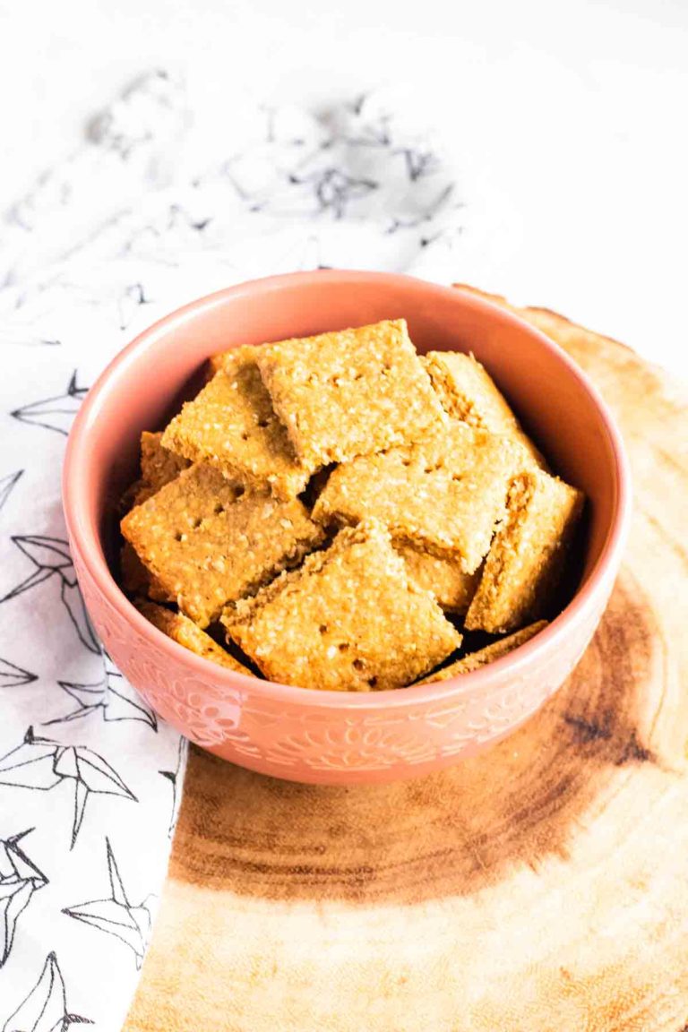 a bowl of homemade dog treats on a wood serving slab