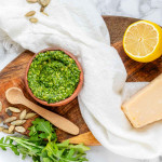 Vibrant green pesto in an orange clay bowl.