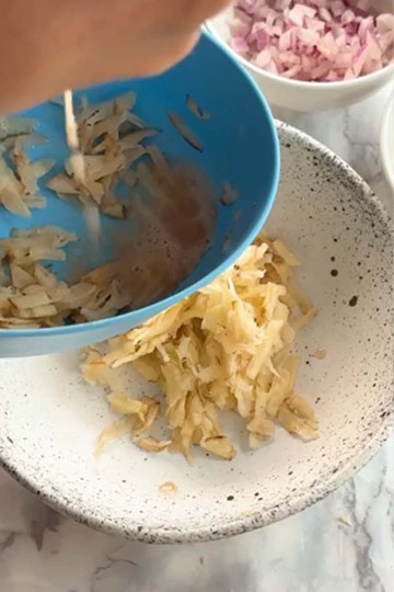 The water is squeezed out of grated potato.