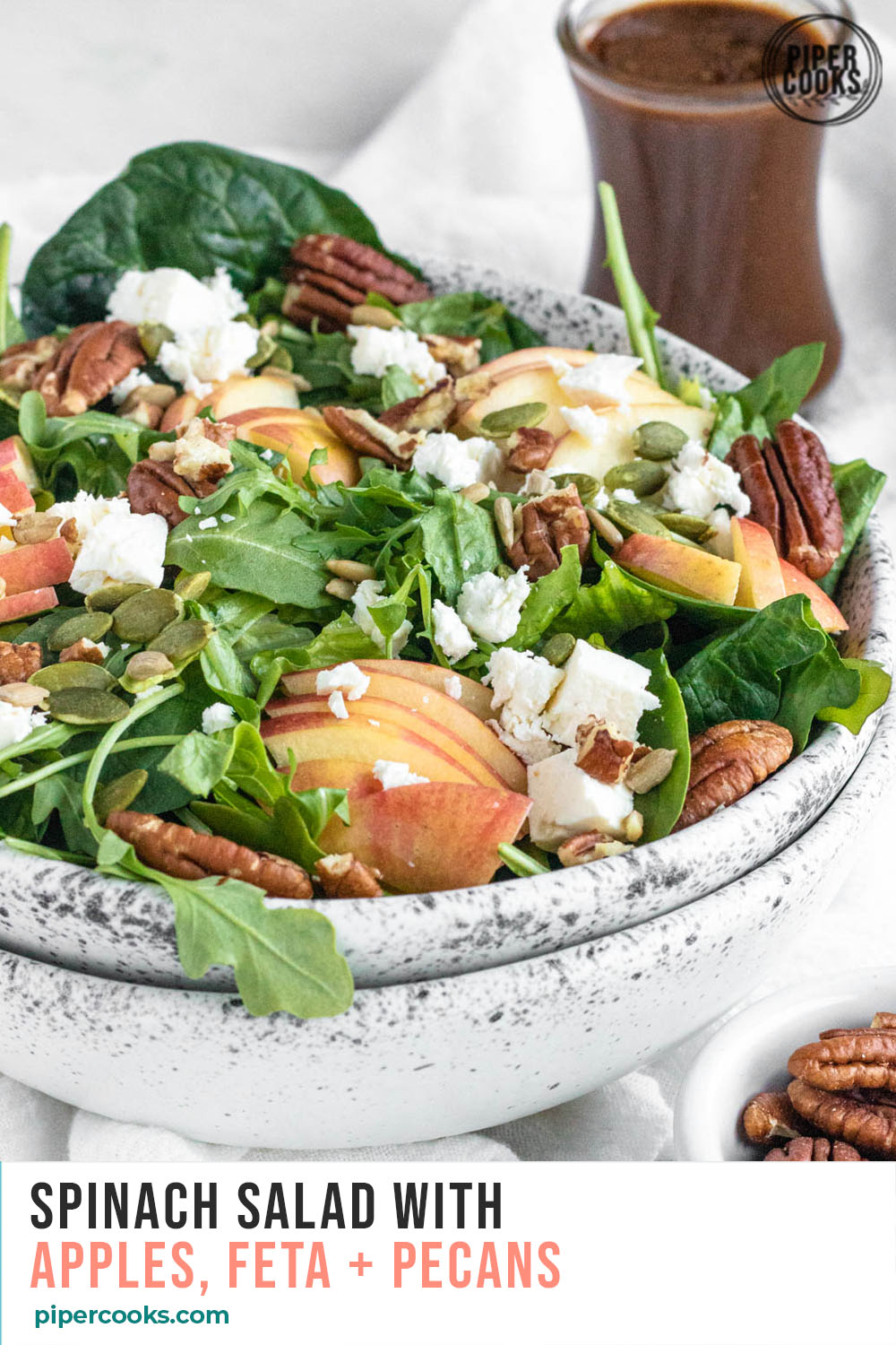 Spinach Salad with Apples in a bowl with text overlay for Pinterest
