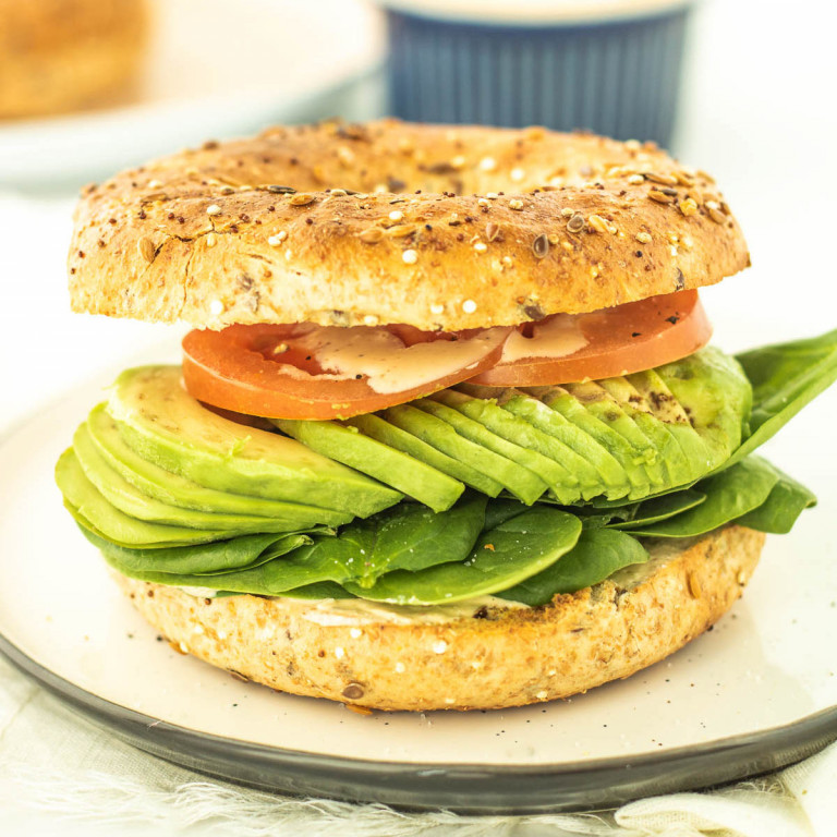 toasted bagel sandwich with tomato, avocado and spinach
