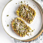 smashed avocado on toast on a plate with text overly for Pinterest