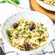 pasta salad in a bowl with olives on top