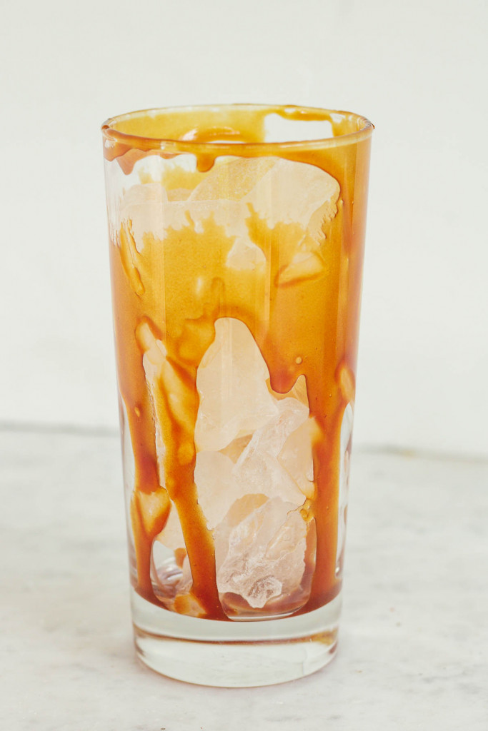 caramel sauce drizzled down the sides of a tall glass of ice