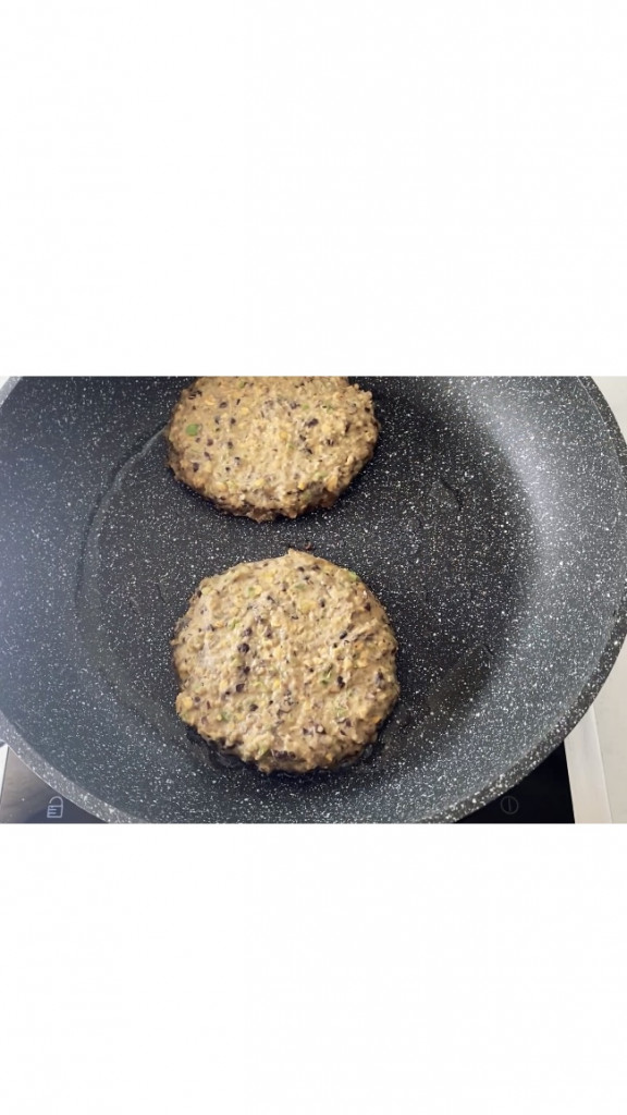 cooking two black bean patties in a frying pan