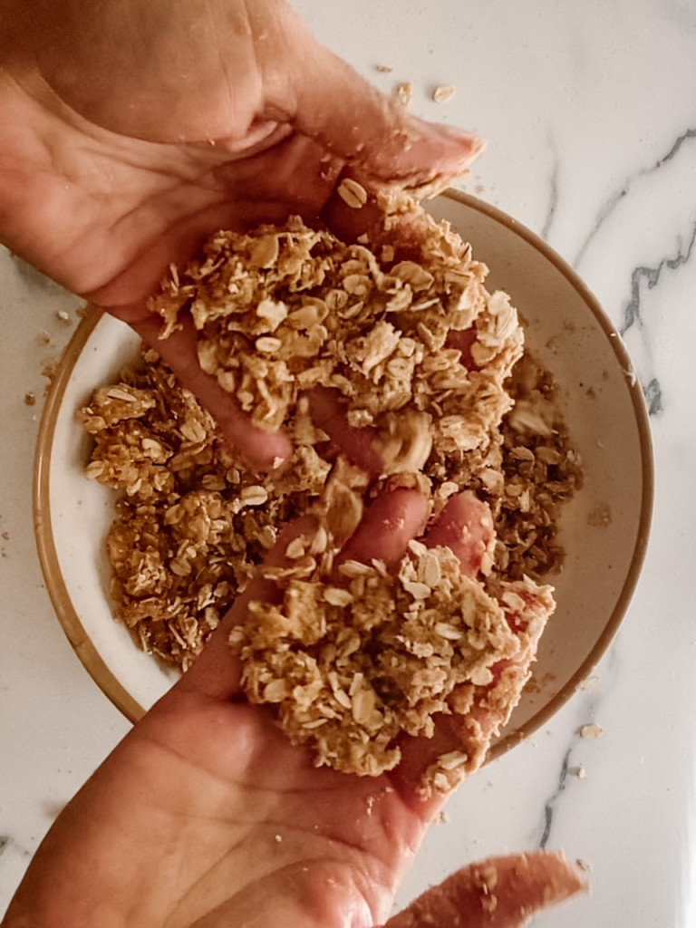 hands holding uncooked streusel topping