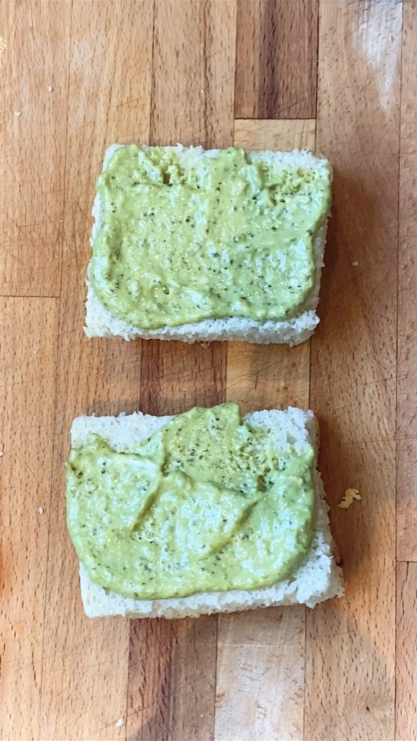 an open sandwich with pesto mayo spread on the bread.
