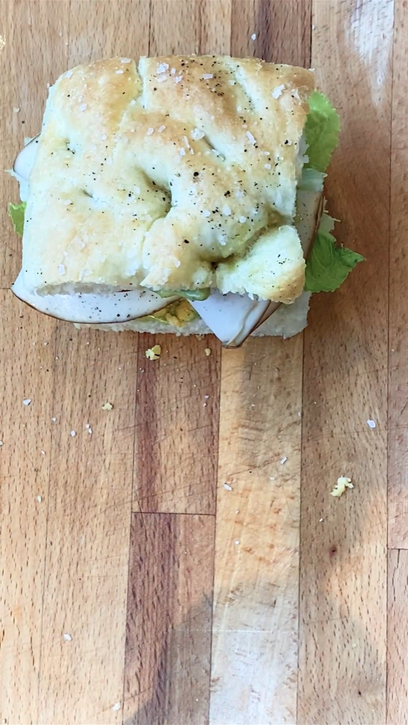 top down view of a sandwich on a cutting board.