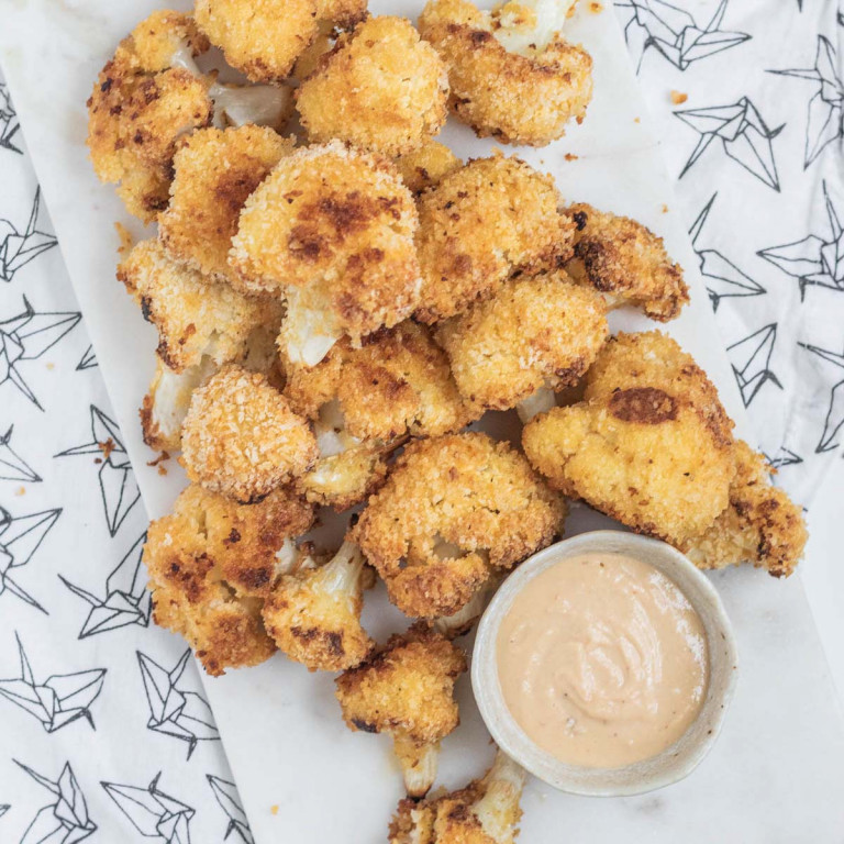 breaded cauliflower pieces on a marble slab.