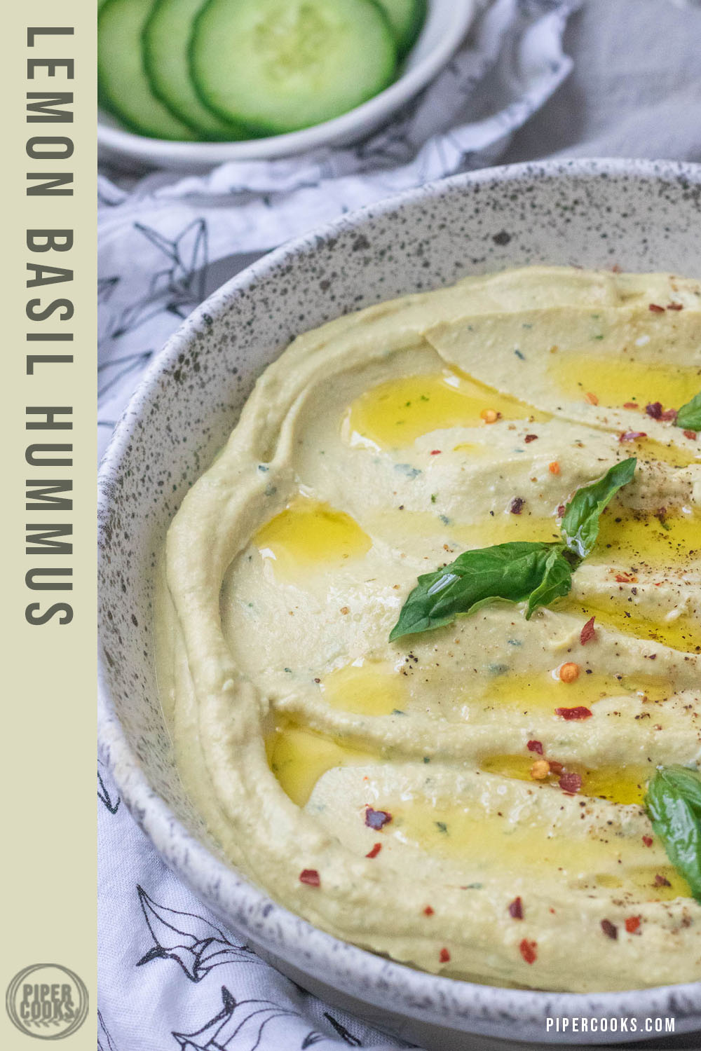 Hummus garnished with basil and olive oil in a bowl with text for Pinterest.
