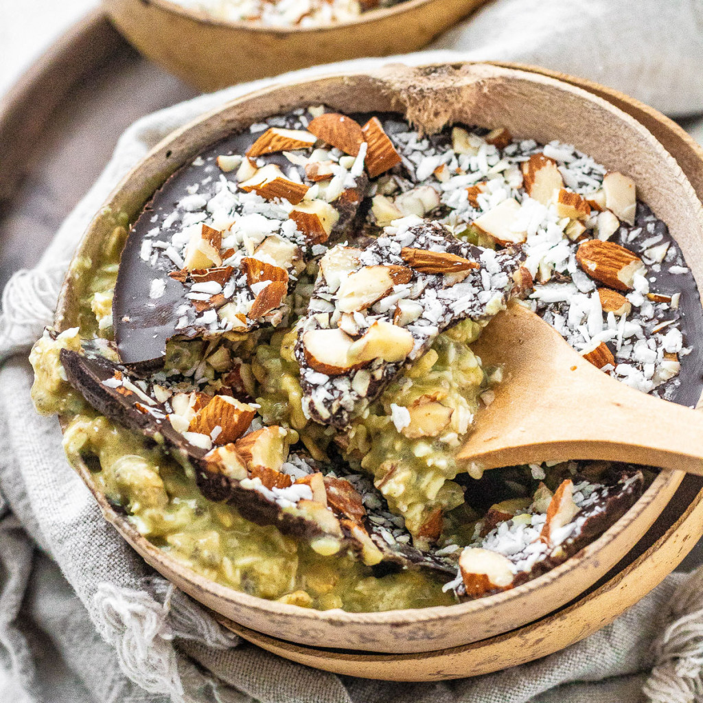 Overnight oats in a coconut bowl with a chocolate, almond, and coconut topping.
