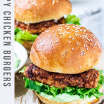 2 chicken burgers on a plate with text title for pinterest.