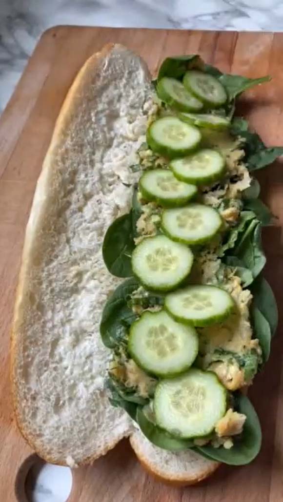 A long sub bun with sandwich ingredients on it.