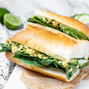 A sandwich filled with avocado chickpea spread.