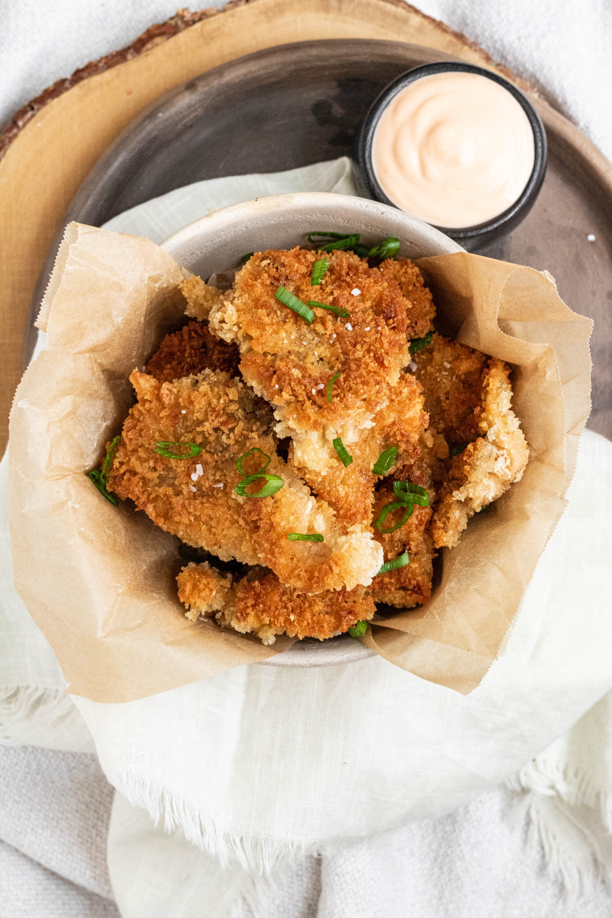 Golden brown breaded and fried mushrooms in a bowl.
