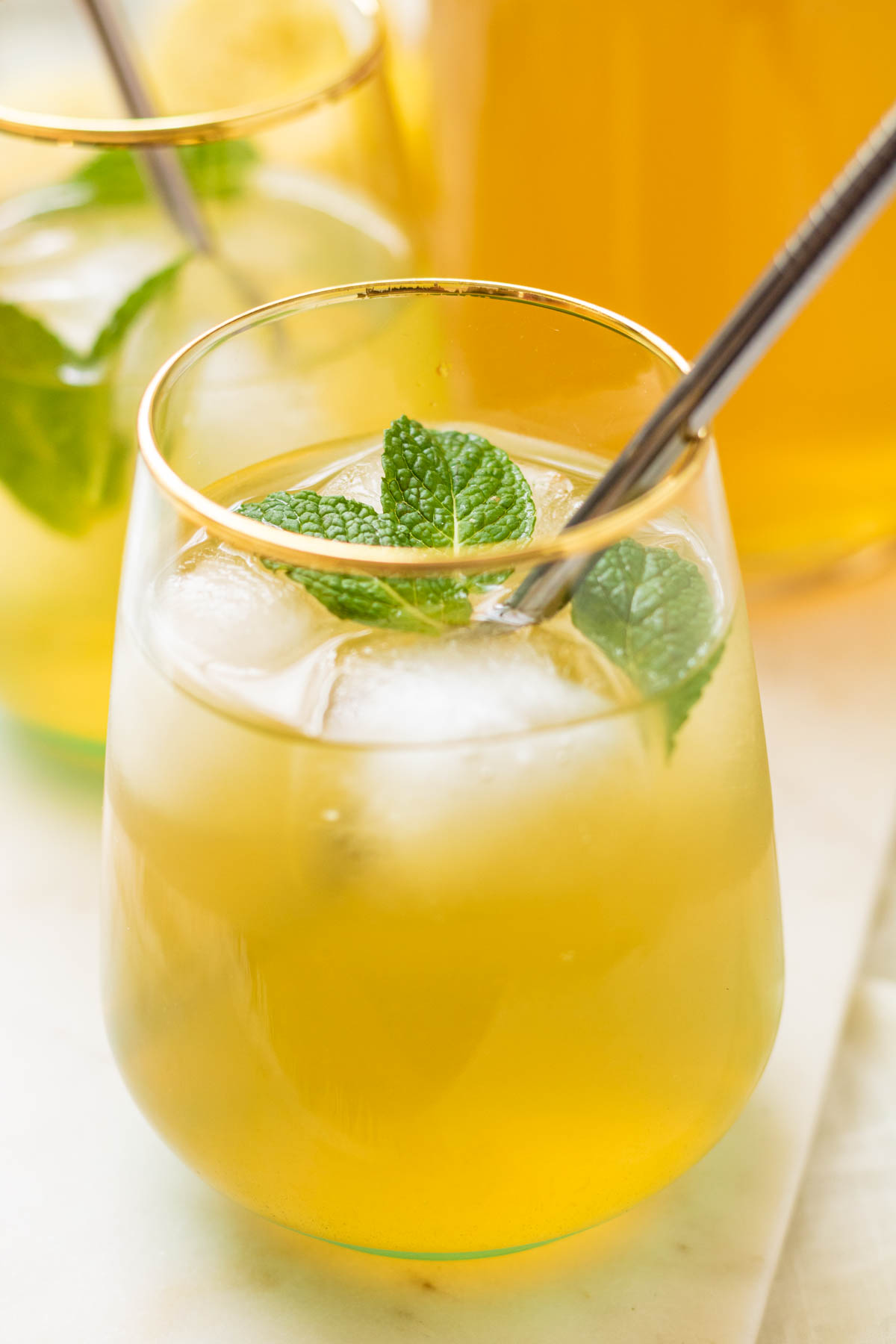 Iced Green Tea Lemonade in glasses with mint and a metal straw.