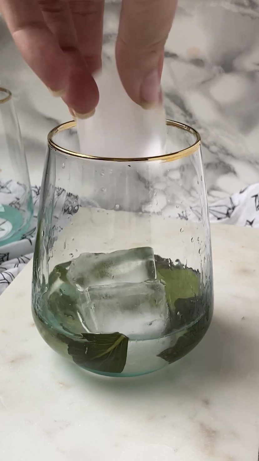 Adding ice to a cocktail glass.