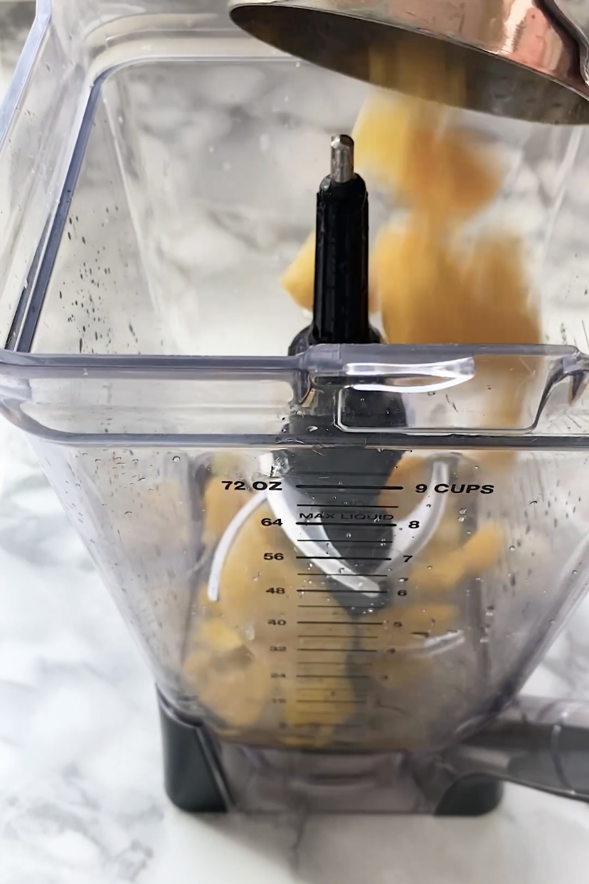 Add frozen mango chunks to a blender.