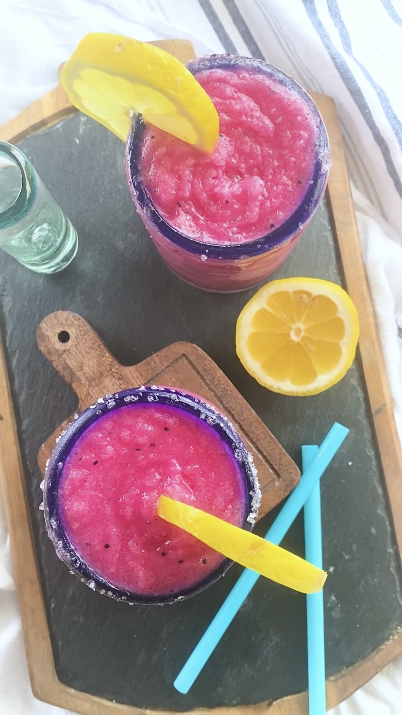 Top down view of two bright pink frozen blended margaritas.