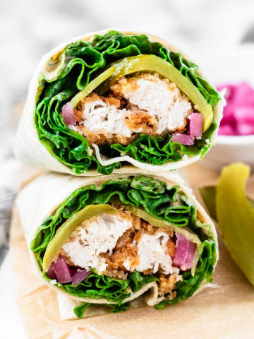 The cut ends of two stacked wraps filling with lettuce, crispy chicken, and lettuce.