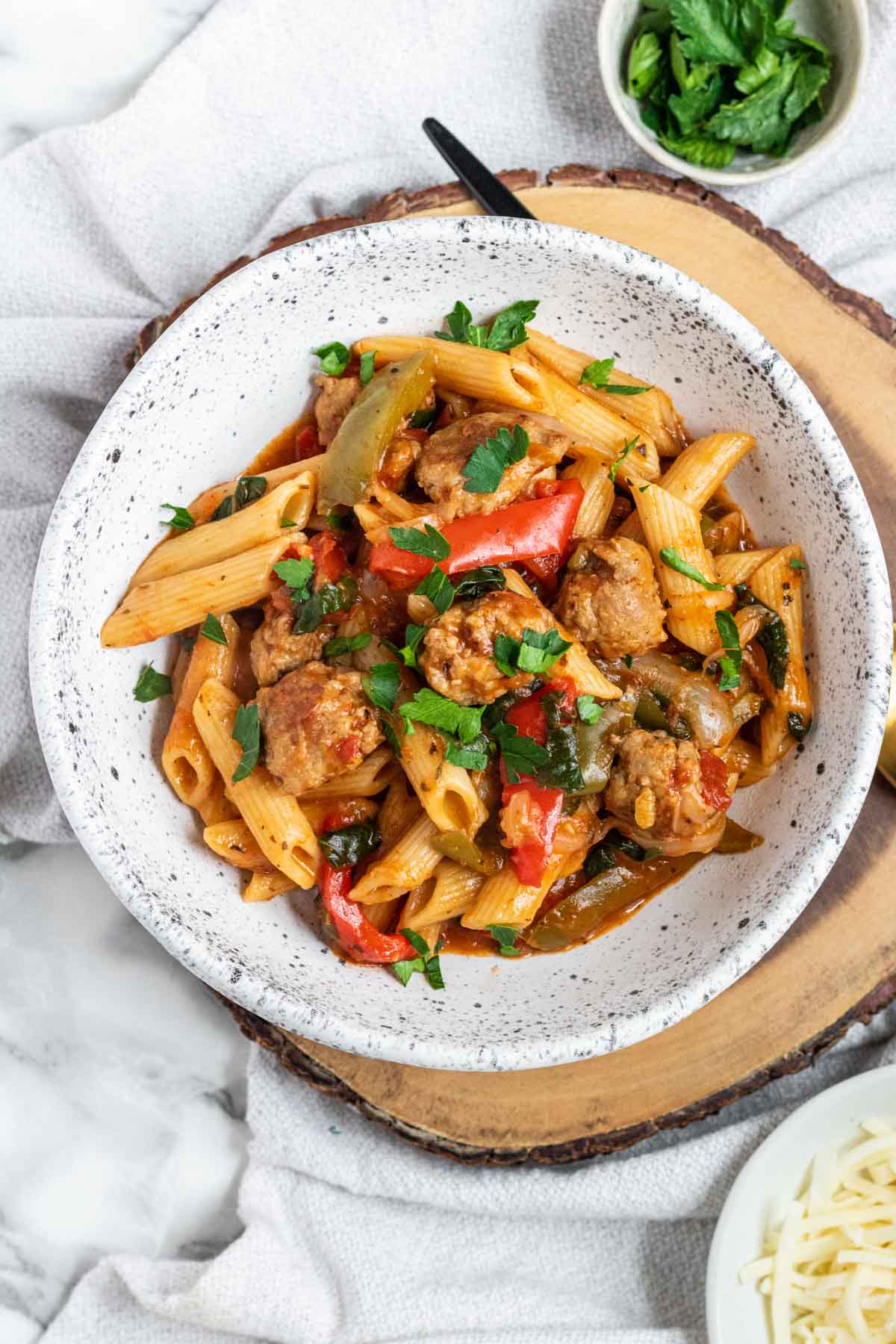 Pasta with sausages and spinach, in a bowl.