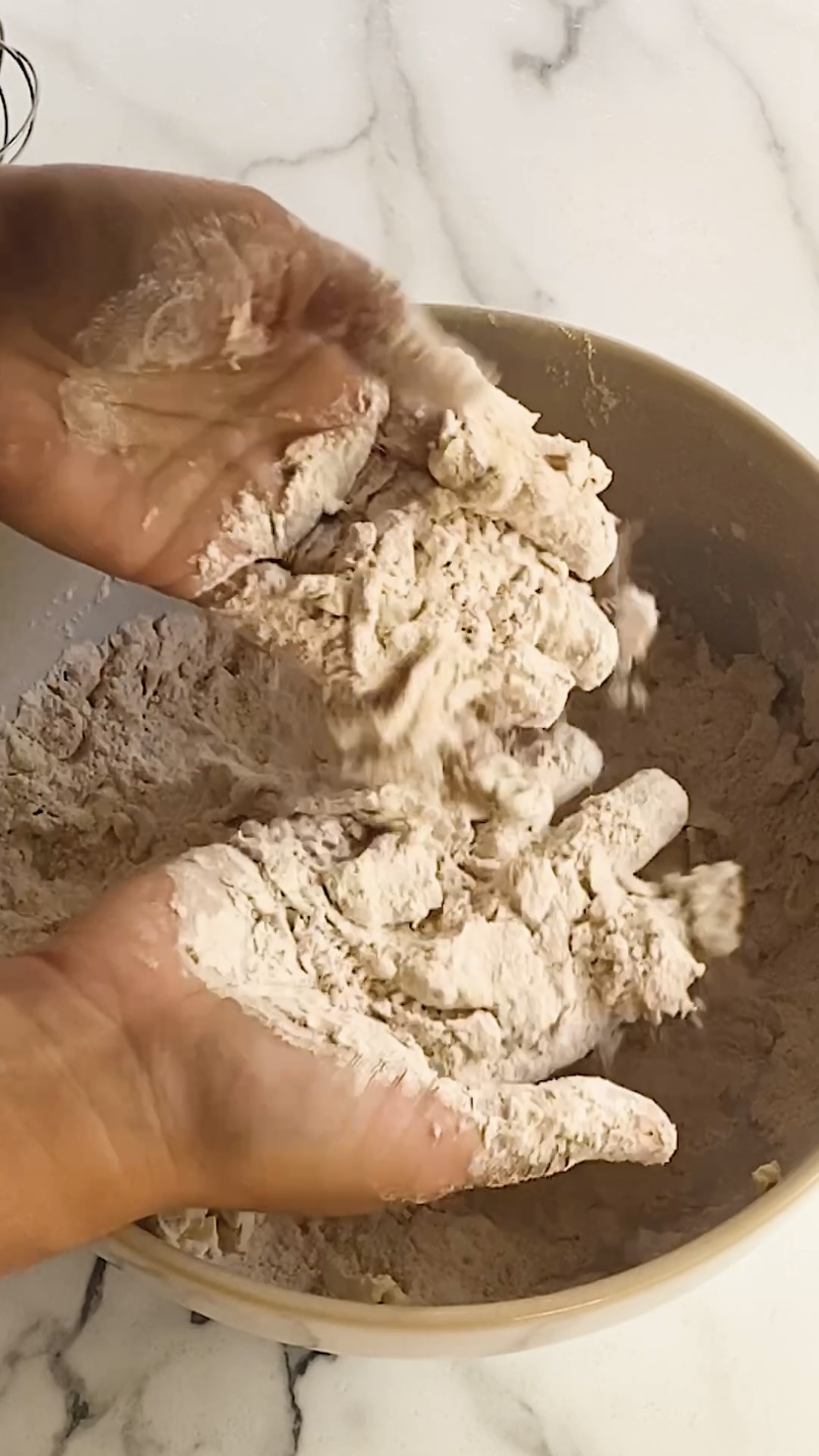Mixing butter into flour with hands.