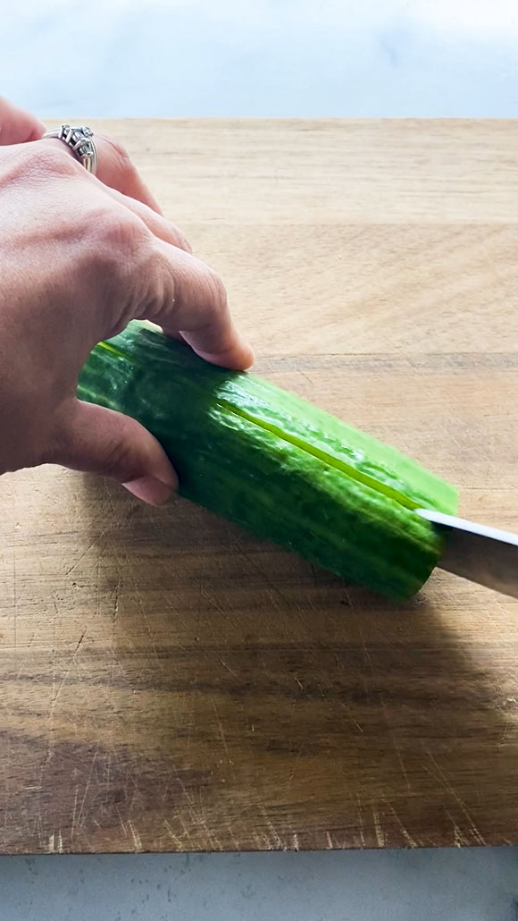 Slicing a cucumber lengthwise.