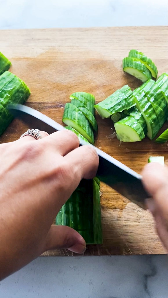 Slicing cucumbers with a knife.