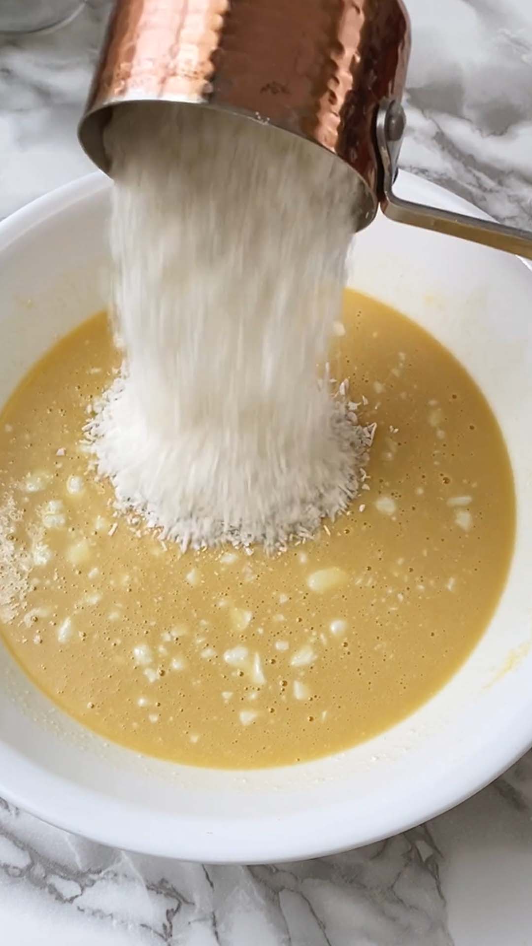 Adding coconut to a cake batter.