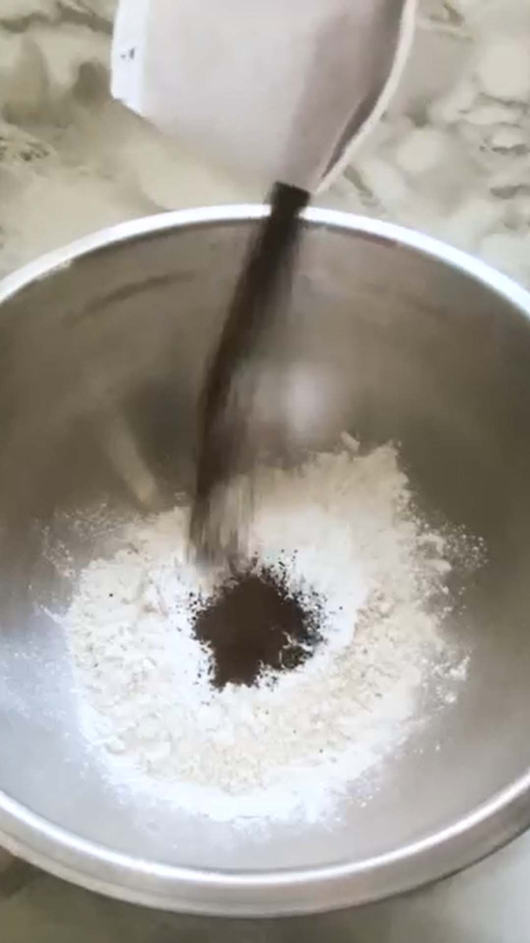 Adding earl grey tea leaves to a bowl of flour.