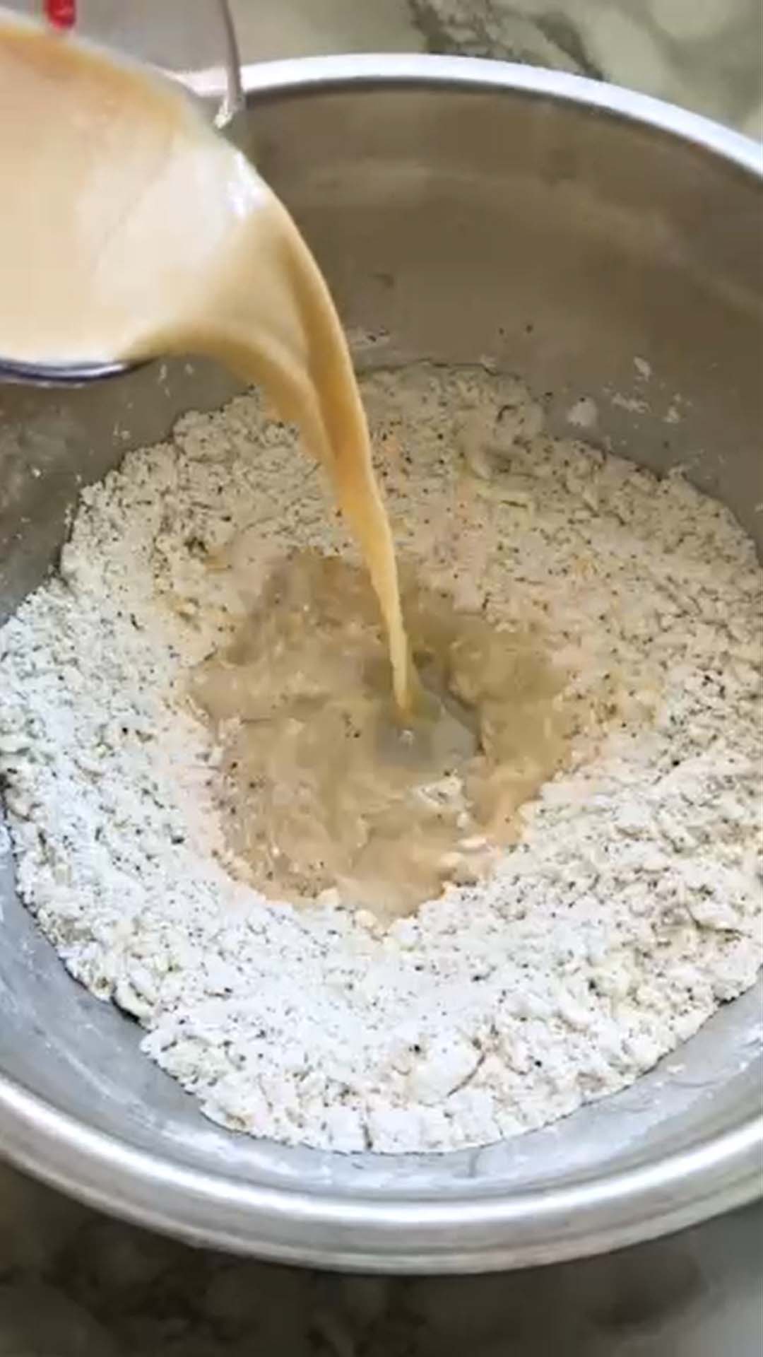 Pouring liquid in buttered flour for scones.