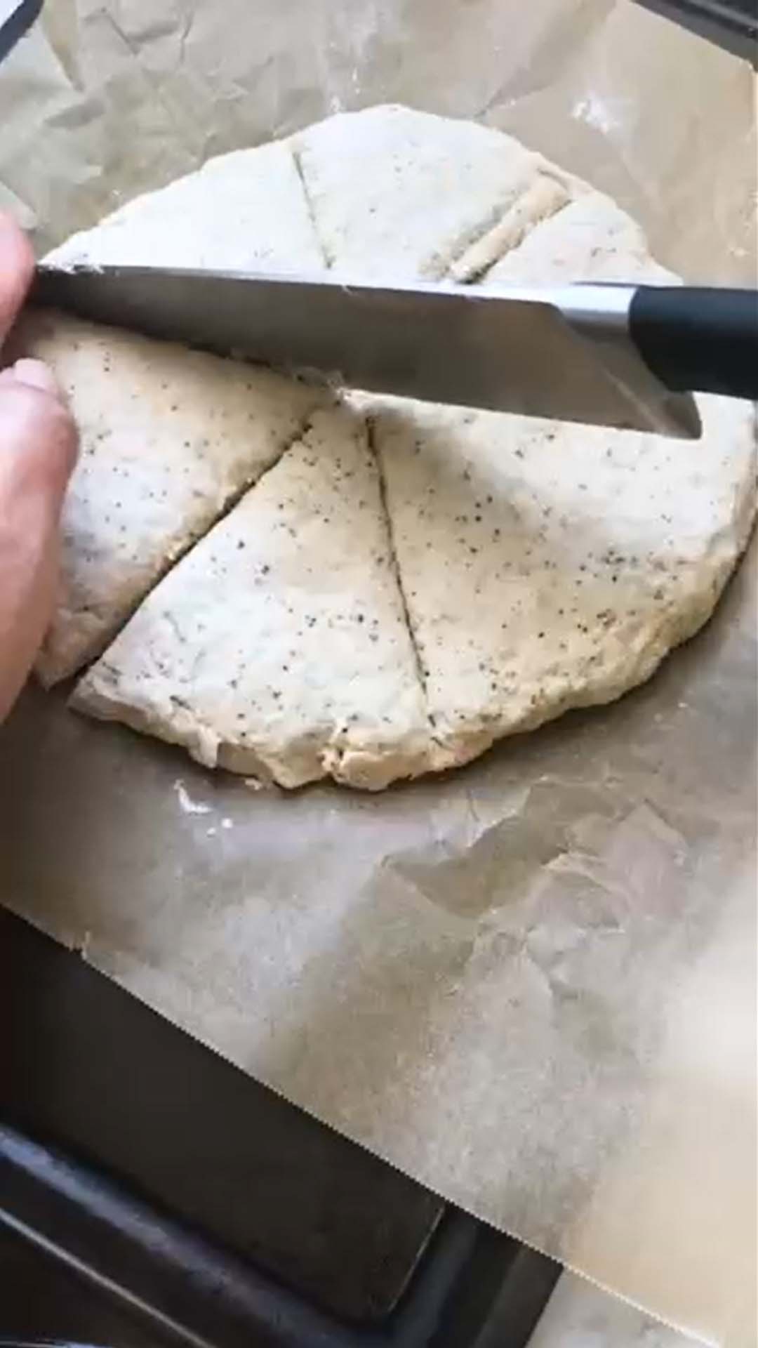 Cutting scone dough into 6 pie slices to bake.