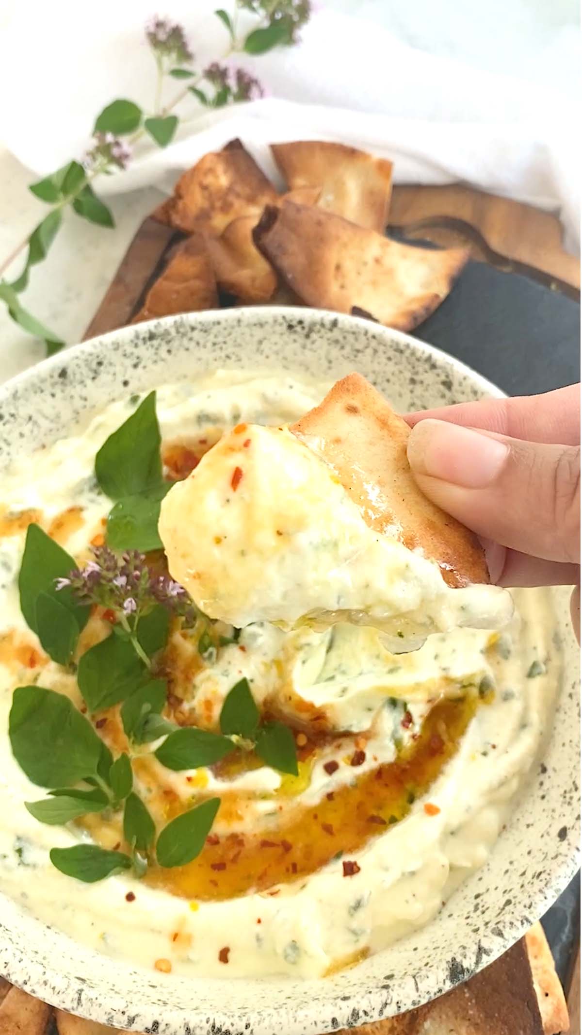 Dipping a pita chip in whipped ricotta.