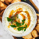 Whipped ricotta dip in a bowl with fresh oregano and hot honey on top.