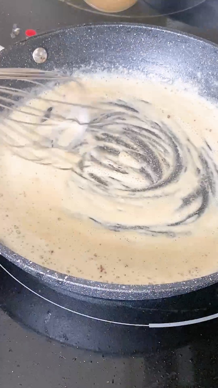 Whisking butter and flour together to make a roux for gravy.