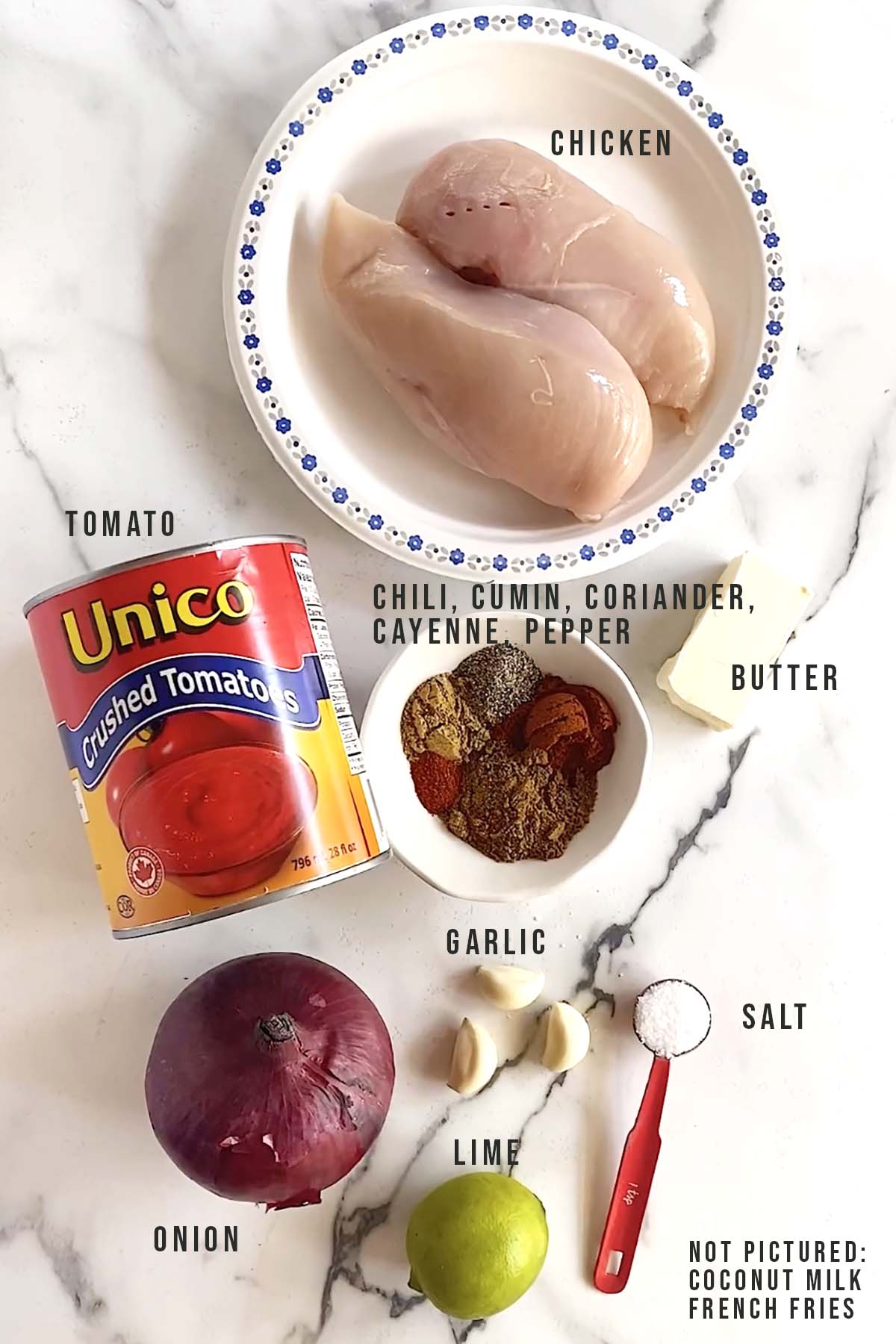 Ingredients for butter chicken on white marble background.