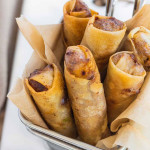 Cheeseburger spring rolls standing in a metal fry basket with a text title.