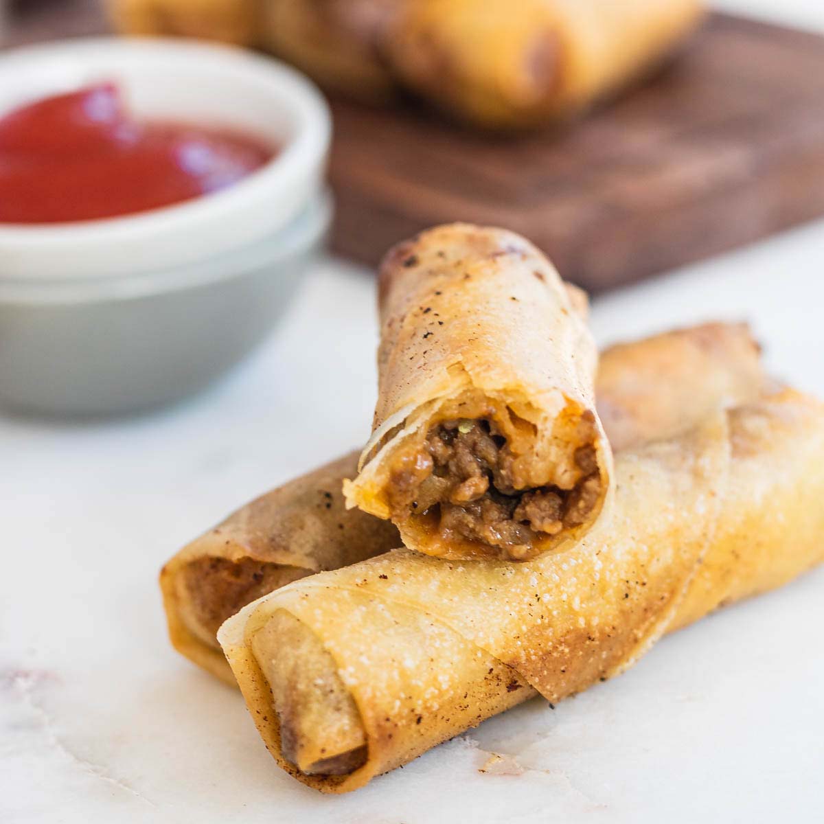 Cheeseburger spring rolls cut in half to show the filling.