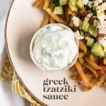 Greek tzatziki sauce in a bowl beside fries with a text title.
