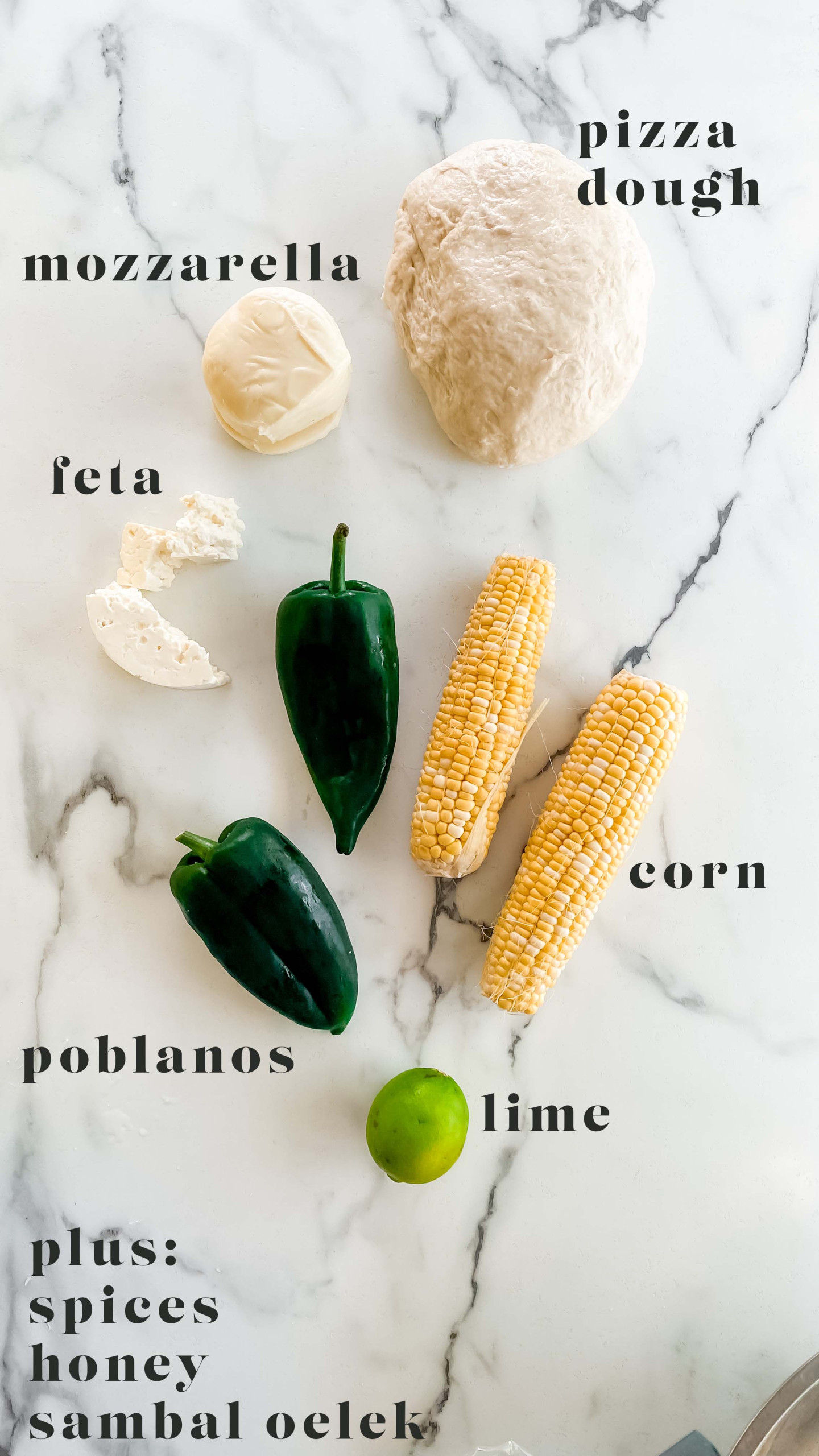 Ingredients for a poblano pizza on a white marble counter.
