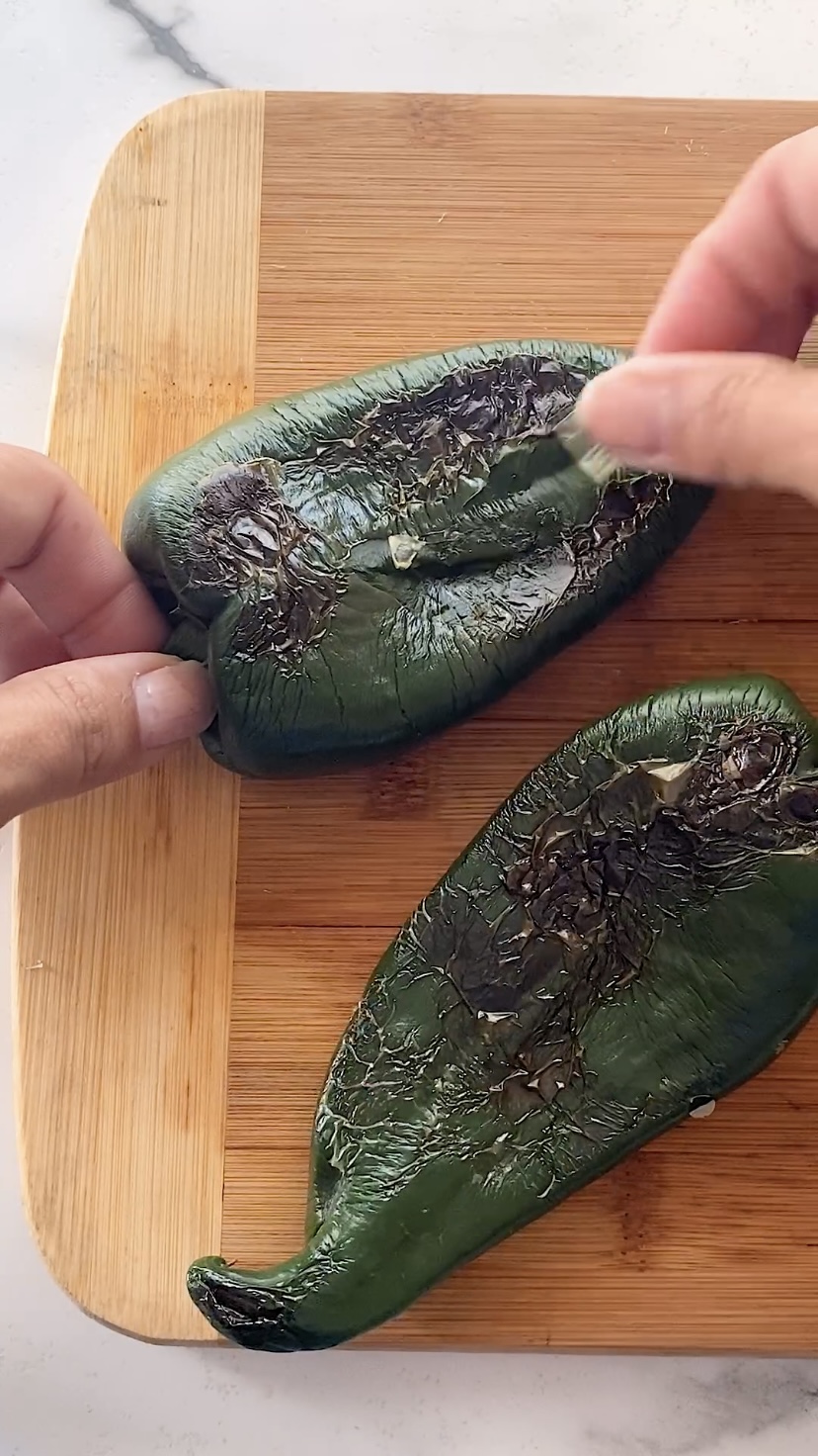 Peeling the skin off of a roasted poblano pepper.