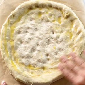 Spreading oil in pizza crust.