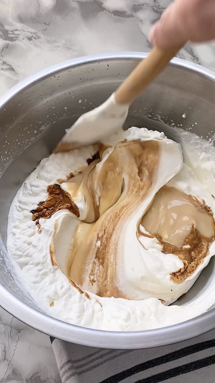 Folding butter pecans into an ice cream base.