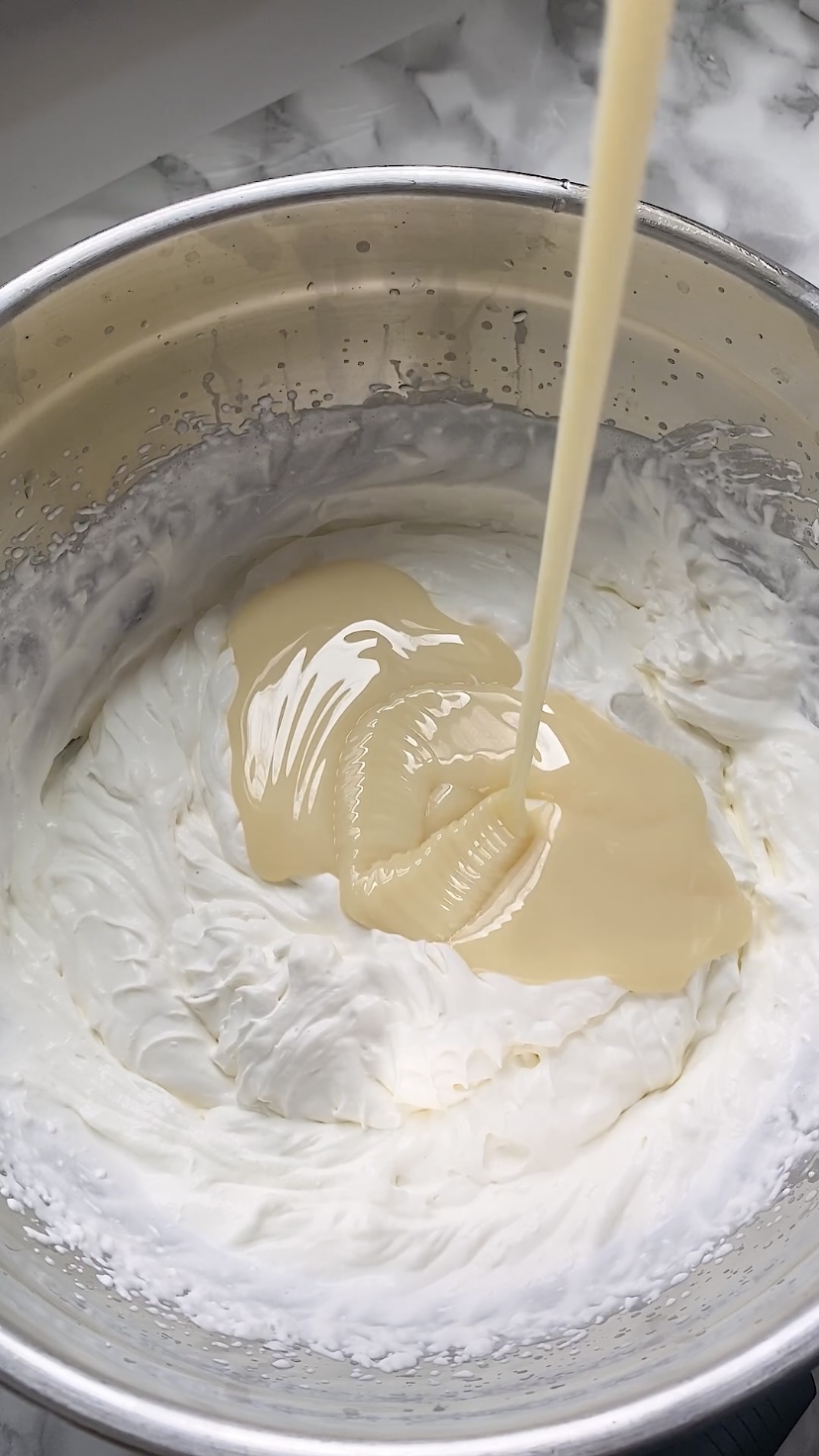 Adding sweetened condensed milk to whipped cream.