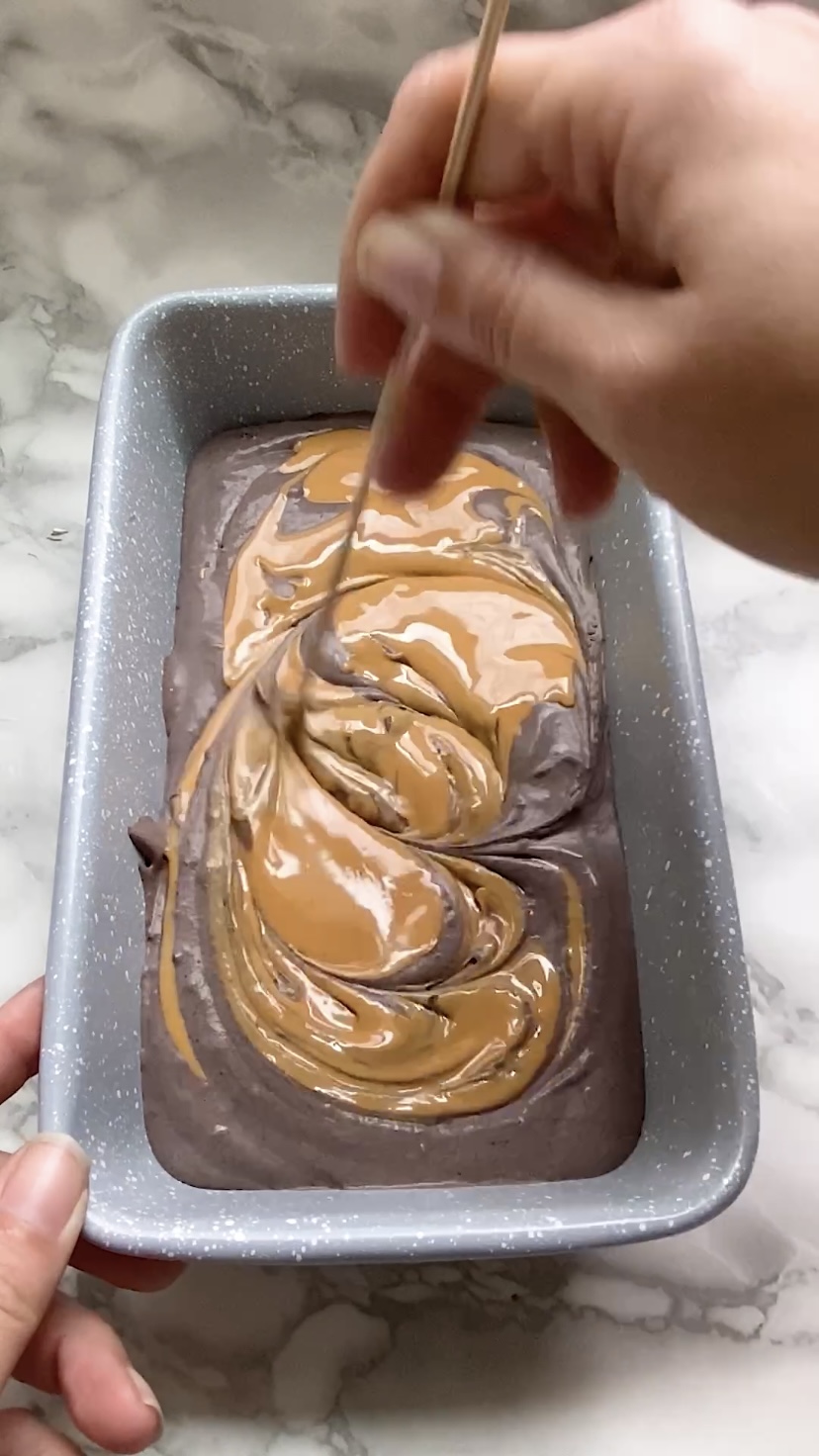 Swirling peanut butter into chocolate ice cream in a loaf pan.
